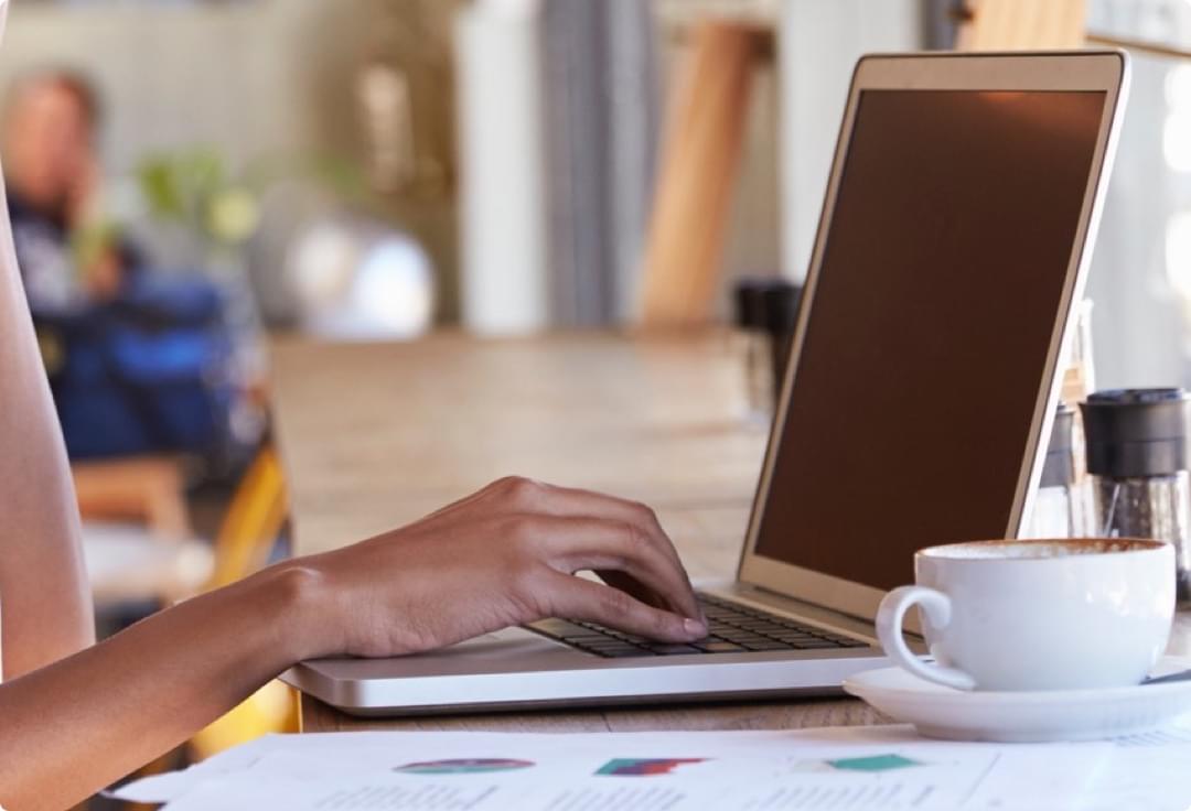 Person using laptop whilst having coffee